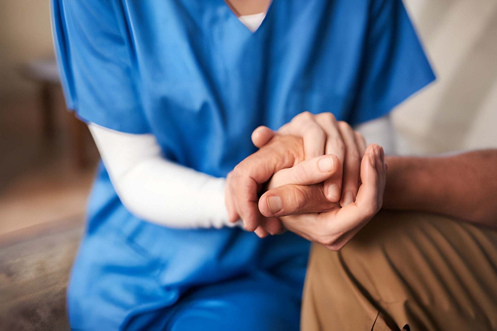 Nurse holding patient's hand - Care Transit Solutions